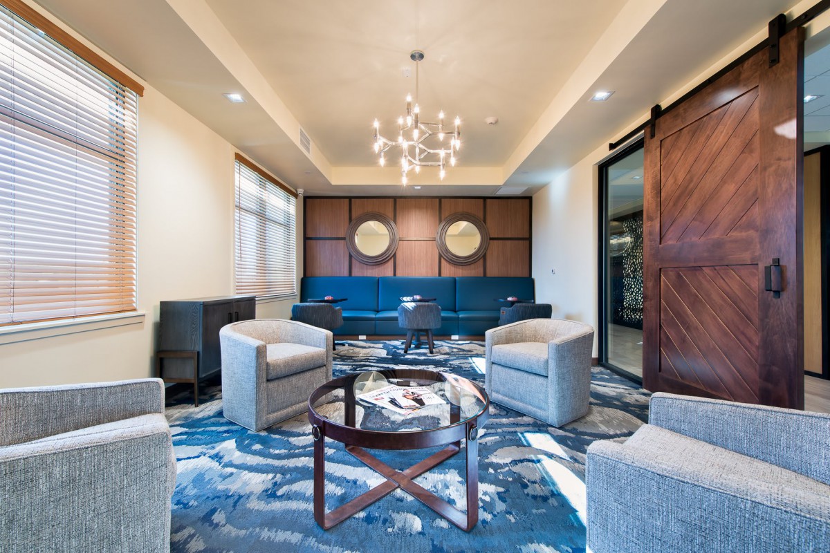 A modern living room with elegant seating and a central chandelier.