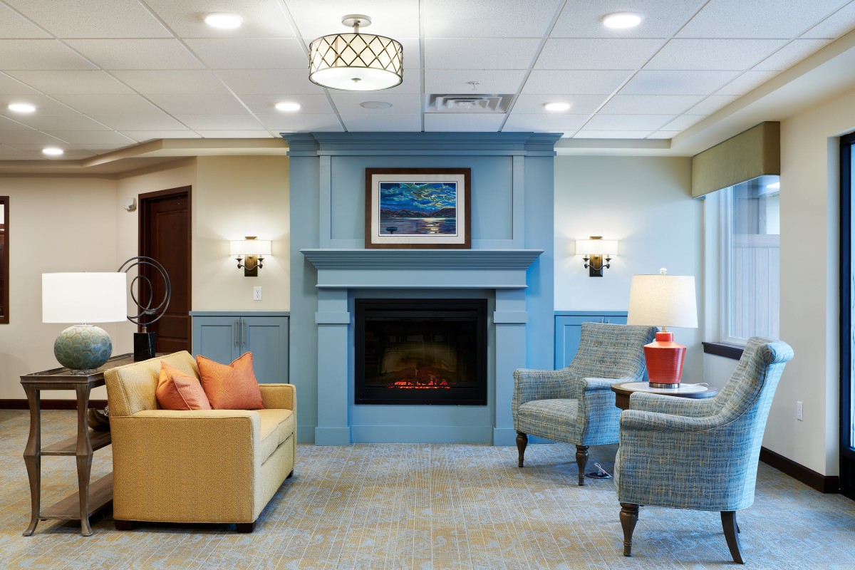 A cozy modern living room featuring a blue fireplace, comfortable seating, and stylish decor.