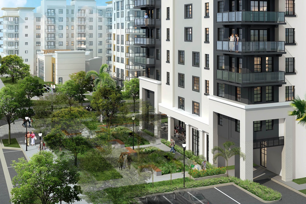 A view of modern apartment buildings with a landscaped green space and parking lot.