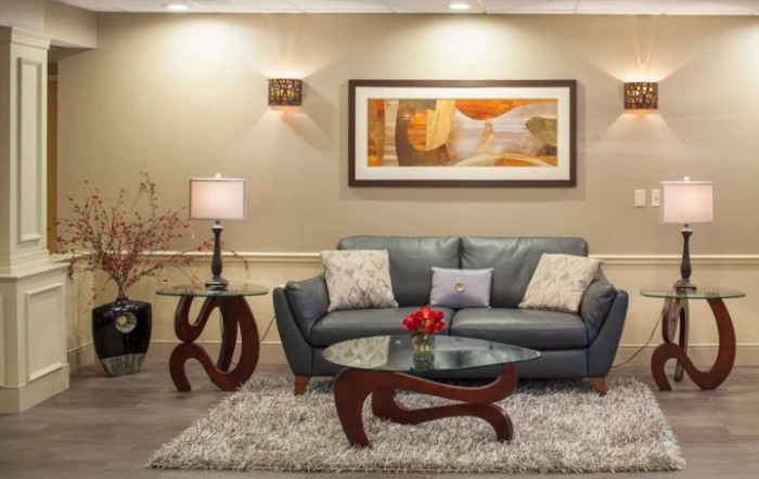 A modern living room featuring a sleek grey sofa, artistic coffee table, and abstract wall art.