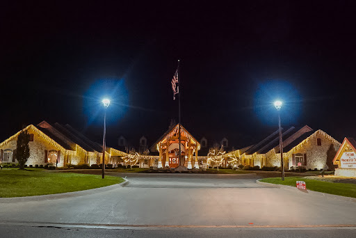 An illuminated building with a flag at night, showcasing a peaceful landscape.