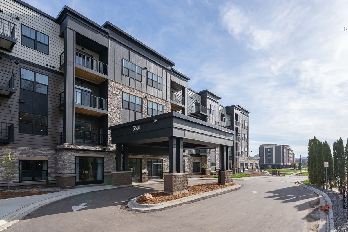 A modern multi-story apartment building with large windows and balconies, showcasing contemporary urban residential design.