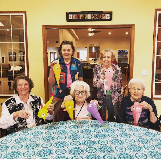 A joyful gathering of seniors showcasing their colorful crafts in a vibrant community setting.