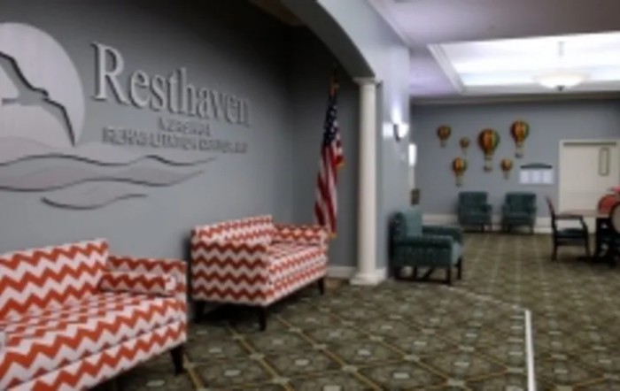 The image shows a lobby area with patterned seating, an American flag, and decorative elements on the wall.