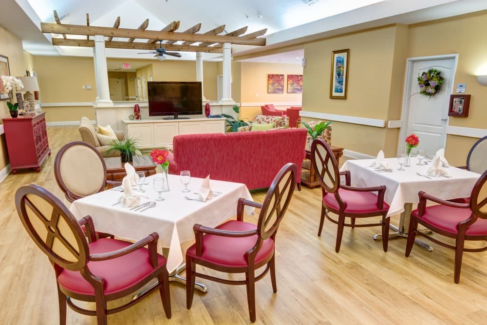 A cozy dining and lounge area with tables, chairs, and a TV.
