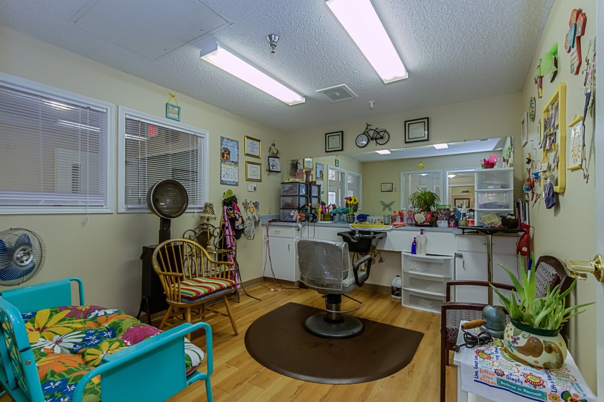 A cozy hair salon with a styling chair, mirrors, and a hair dryer.