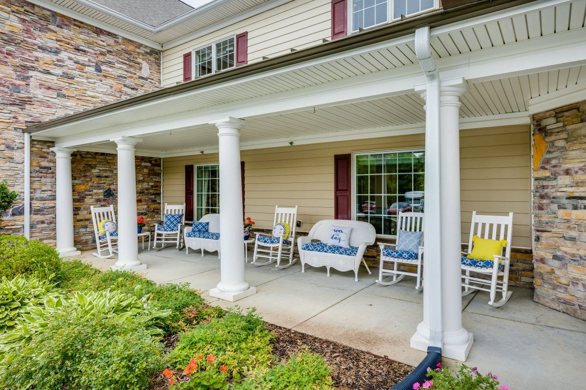 A welcoming front porch with rocking chairs and white columns.