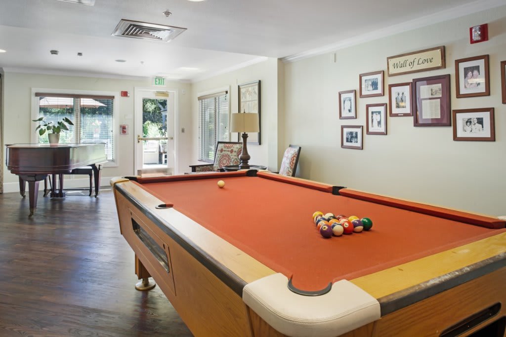 A cozy game room featuring a pool table and wall decorations.