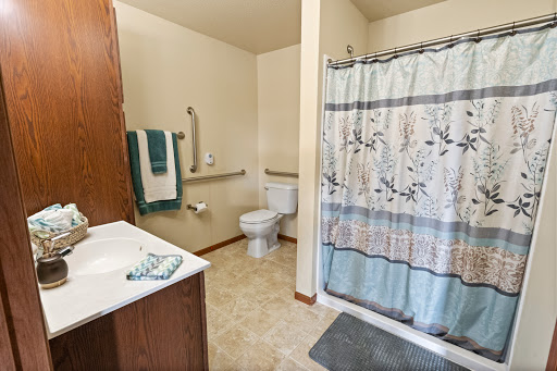 A clean and organized bathroom featuring a shower, toilet, and sink.