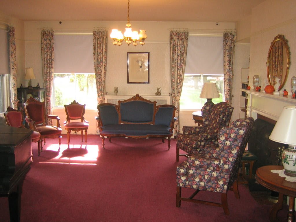 A cozy living room with vintage furniture and ample natural light.