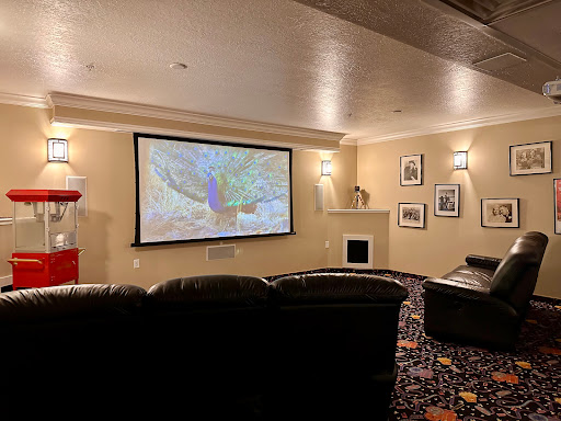 A cozy home theater setup featuring a projector screen and comfortable seating.