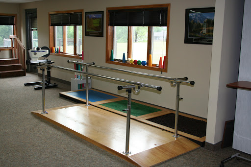 A physical therapy room featuring balancing bars for rehabilitation exercises.