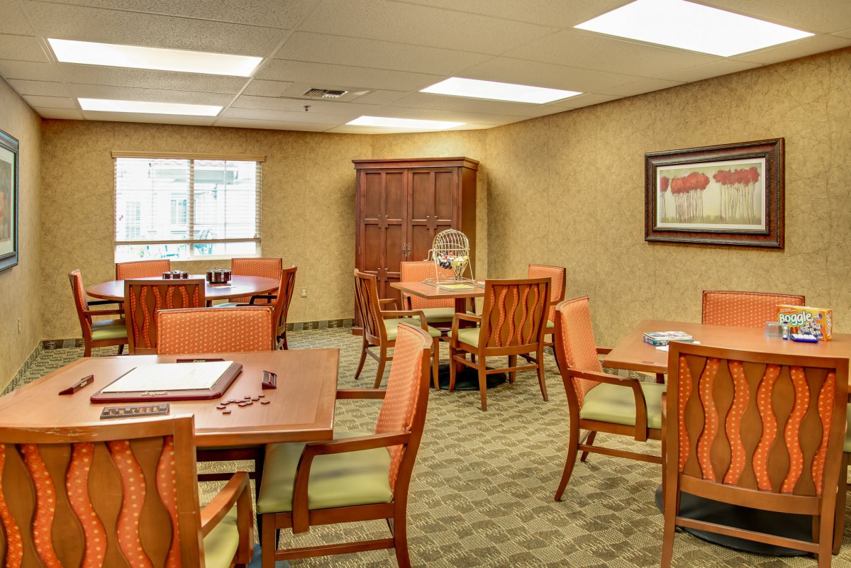 A well-lit dining room with multiple tables and chairs arranged for seating.