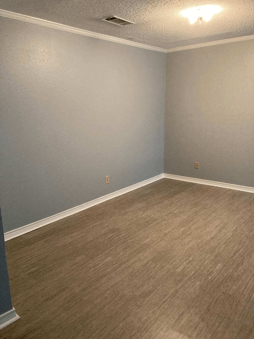 An empty room with beige walls and carpeting.