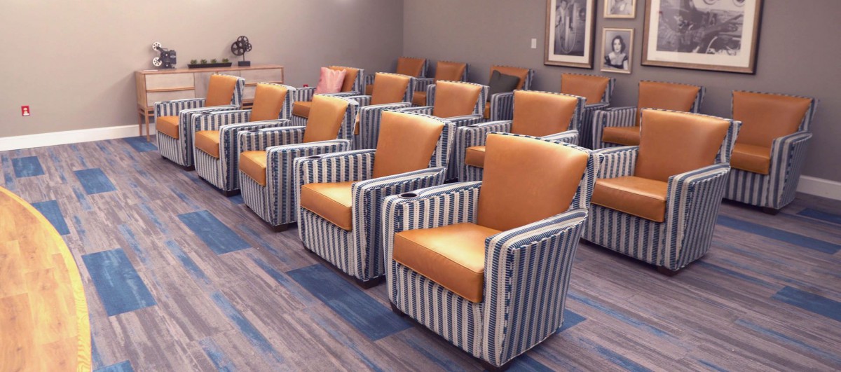 A room with rows of striped chairs featuring orange upholstery.