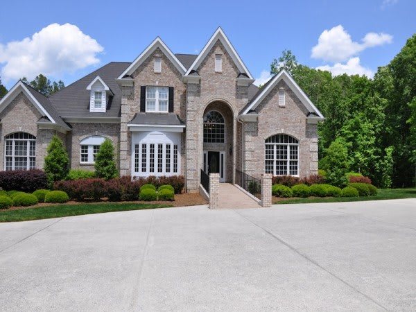 A beautiful luxury home with a spacious driveway and well-maintained landscaping.