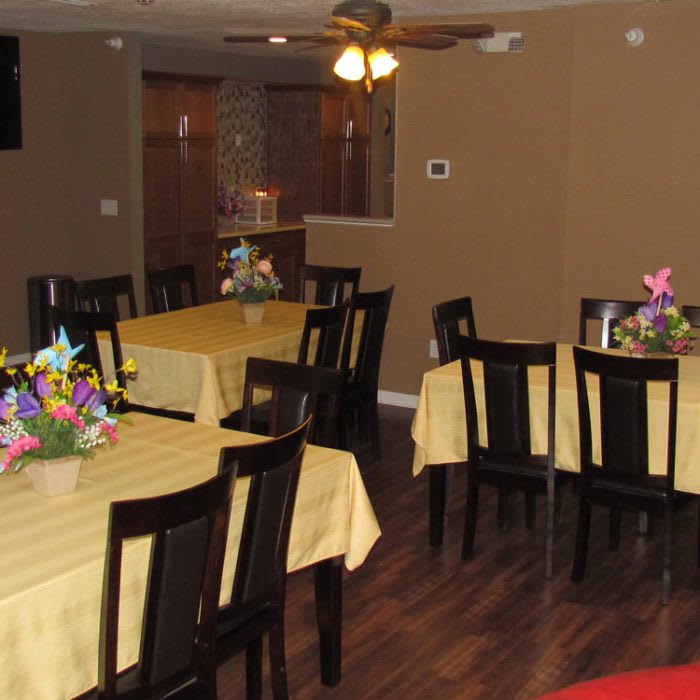 A cozy dining area with neatly arranged tables and floral decorations.