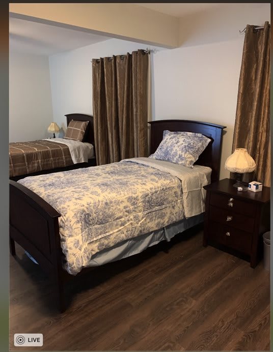 A cozy bedroom with two twin beds, a nightstand, and lamps.