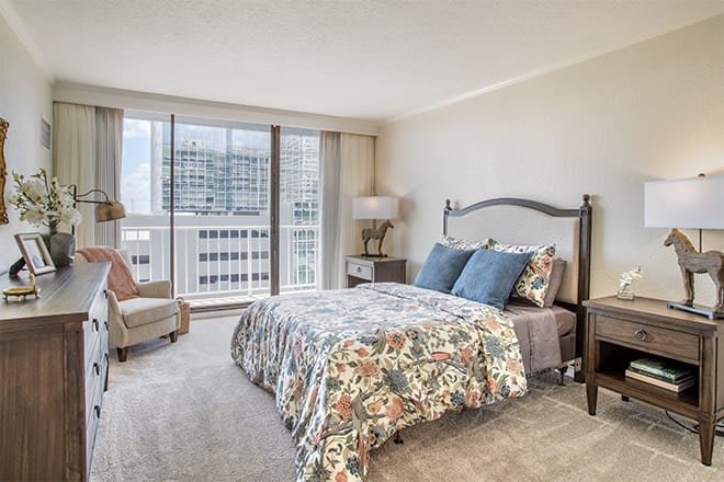 A modern and comfortable bedroom with a city view, featuring stylish decor and furniture.