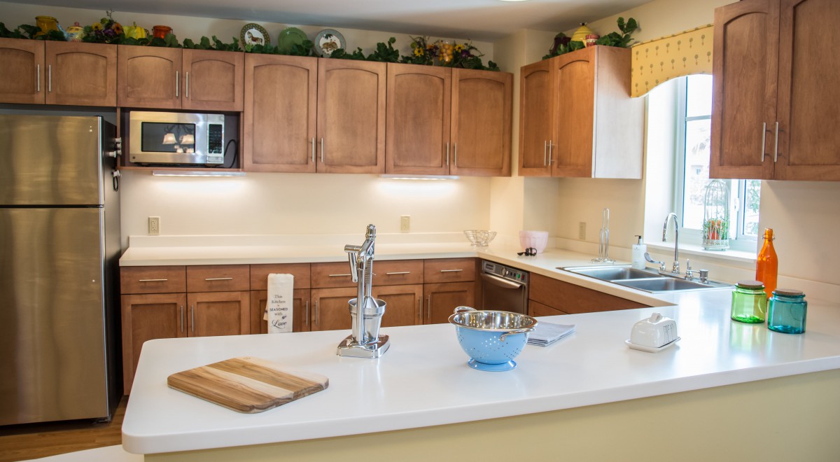 A modern kitchen with wooden cabinets and a clean white countertop.