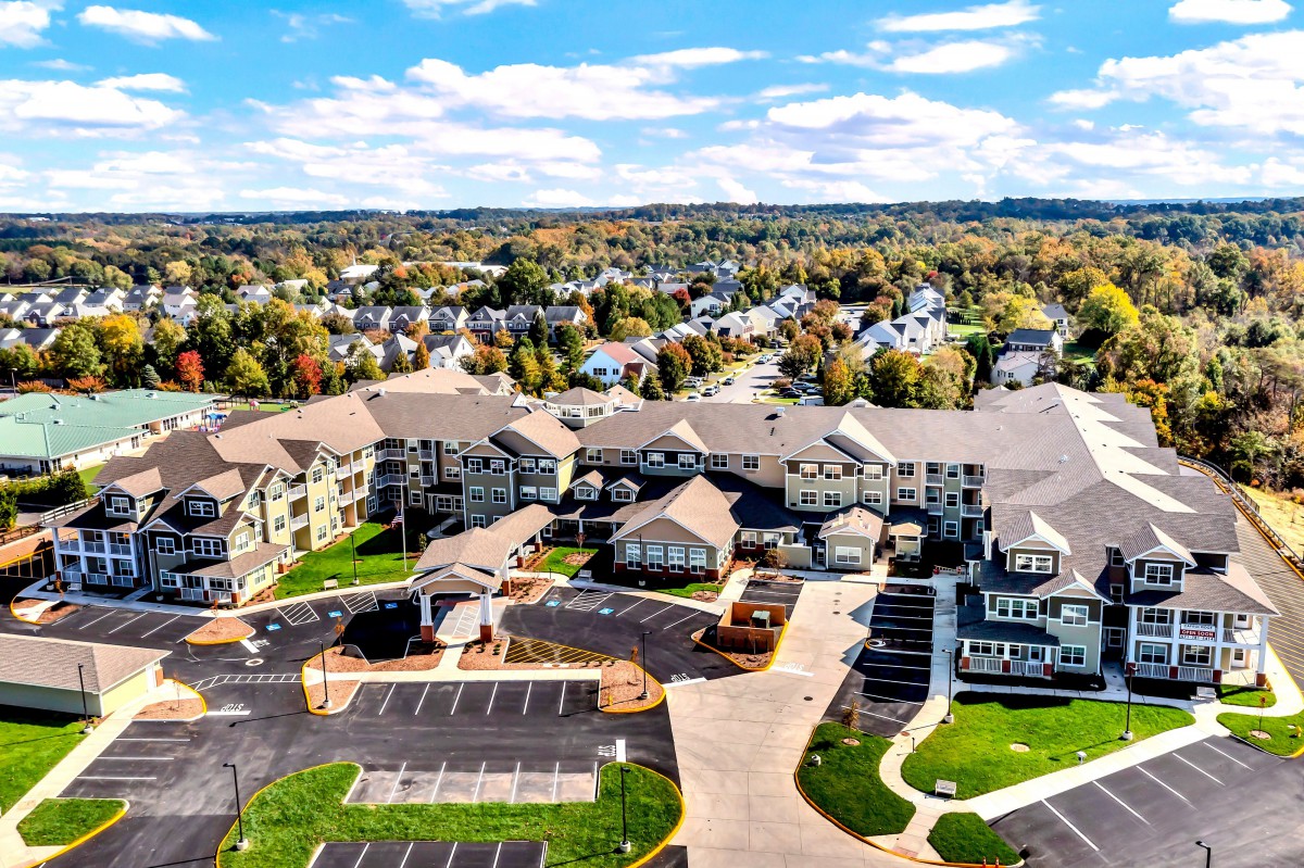 An aerial view of a suburban housing complex with multiple apartment buildings and parking areas.