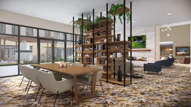 A modern dining area with a large wooden table, stylish chairs, and a shelving unit adorned with plants.