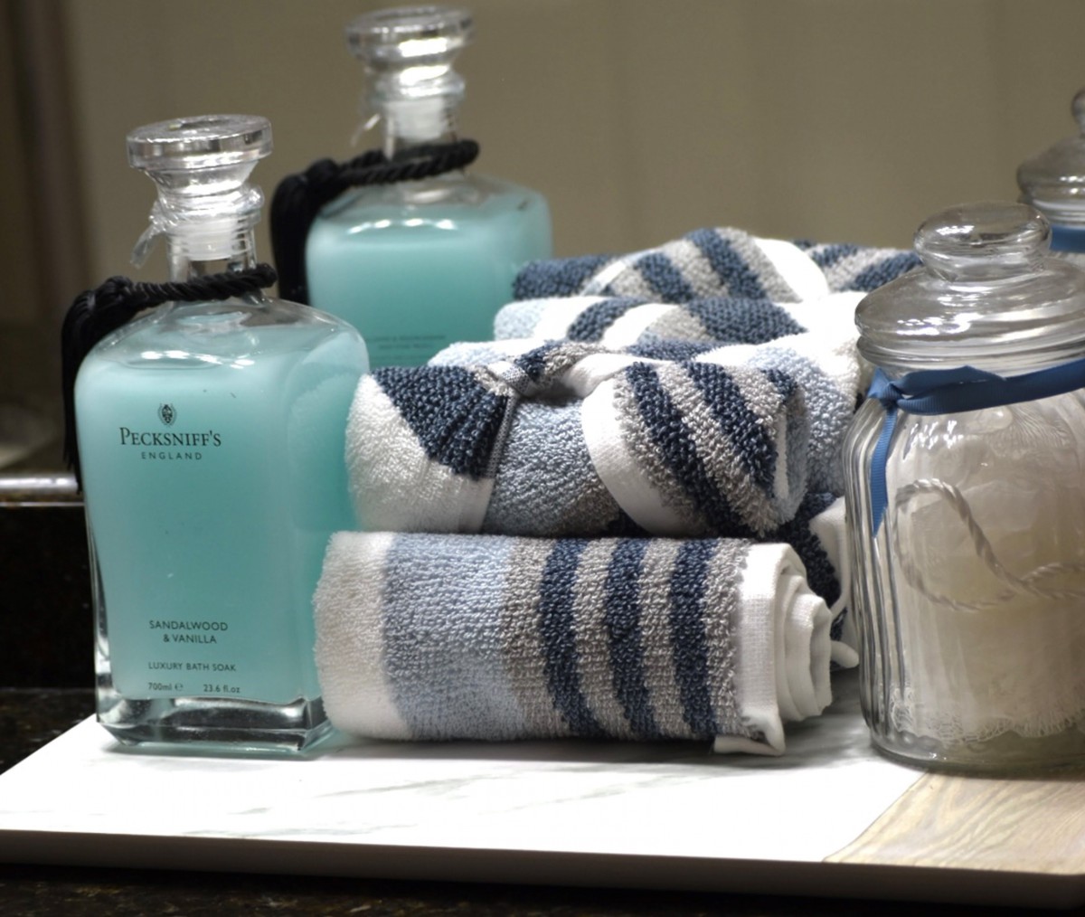 A neatly arranged set of blue-striped towels and bottles of soap adorn a bathroom counter.