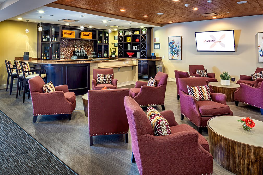 A cozy lounge with comfortable armchairs and a bar area.
