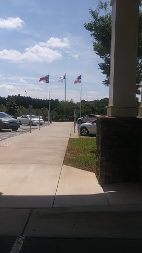 A view of a parking lot with flags flying in the background under a clear sky.