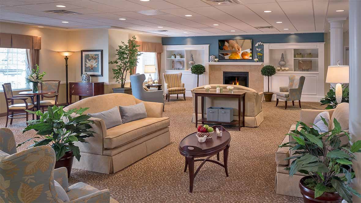 A cozy and elegantly decorated living room with sofas, a coffee table, and a fireplace.