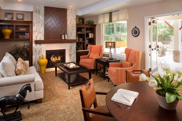 A cozy living room with a fireplace, armchairs, and elegant decor.
