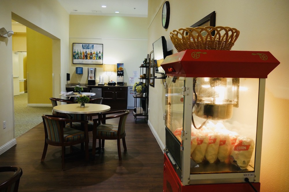 Interior view of a cozy dining area featuring a popcorn machine and wooden furniture.