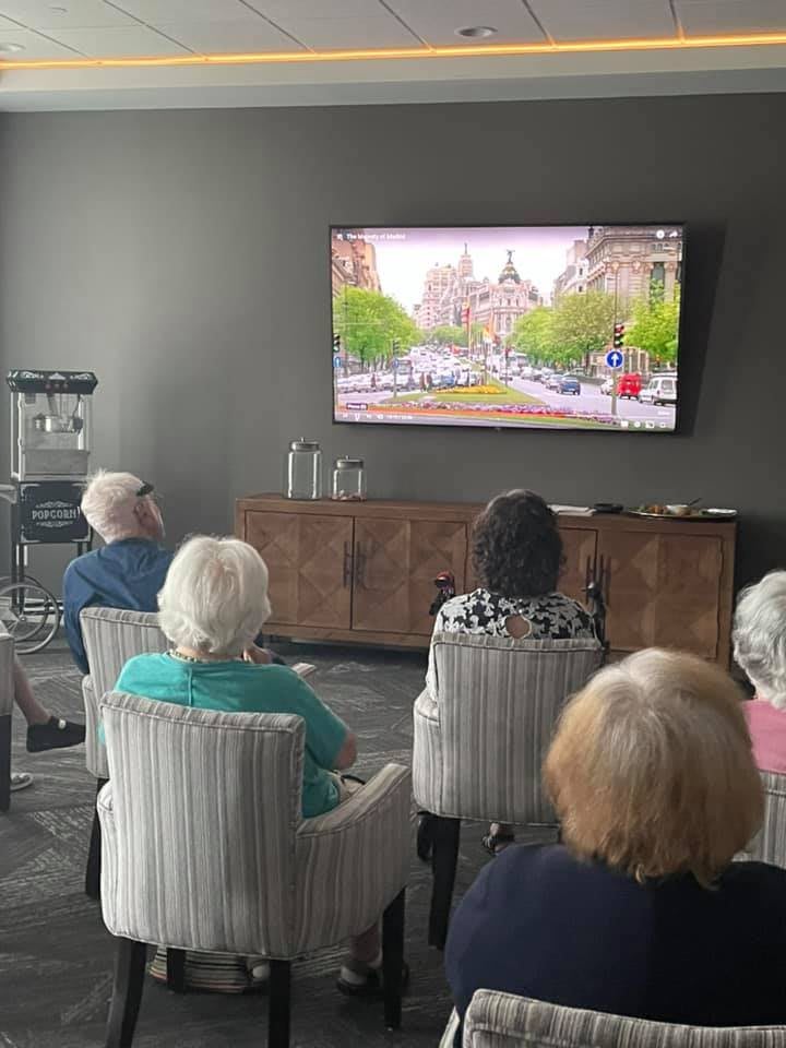 A group of seniors watching television in a living room.