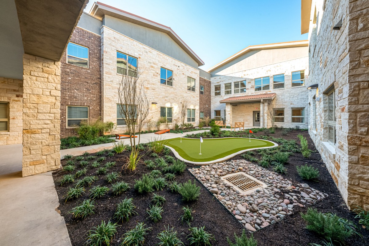 A modern residential building with a well-maintained courtyard garden.
