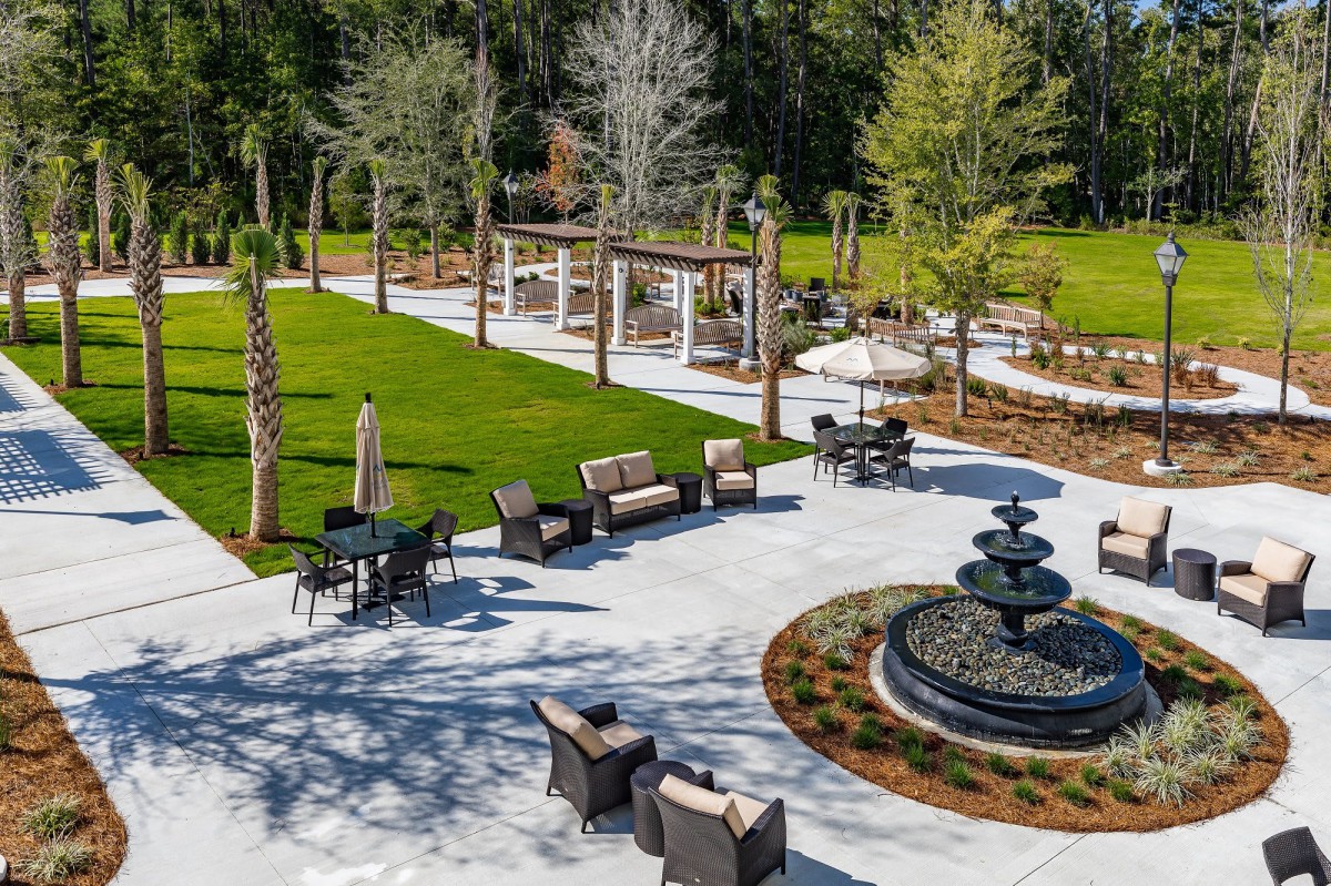 A beautifully landscaped outdoor patio with seating areas and a central fountain.