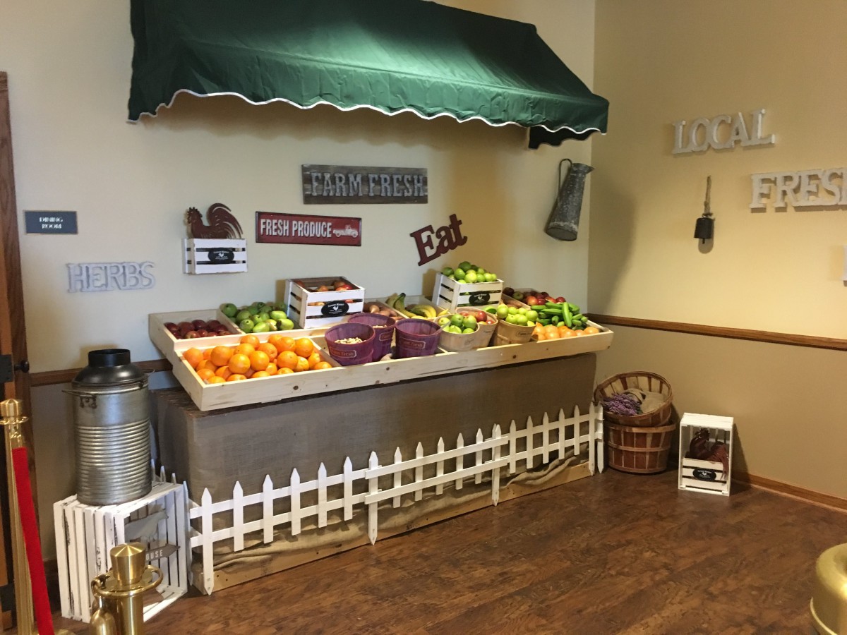 An indoor market stall displaying a variety of fresh fruits and vegetables.