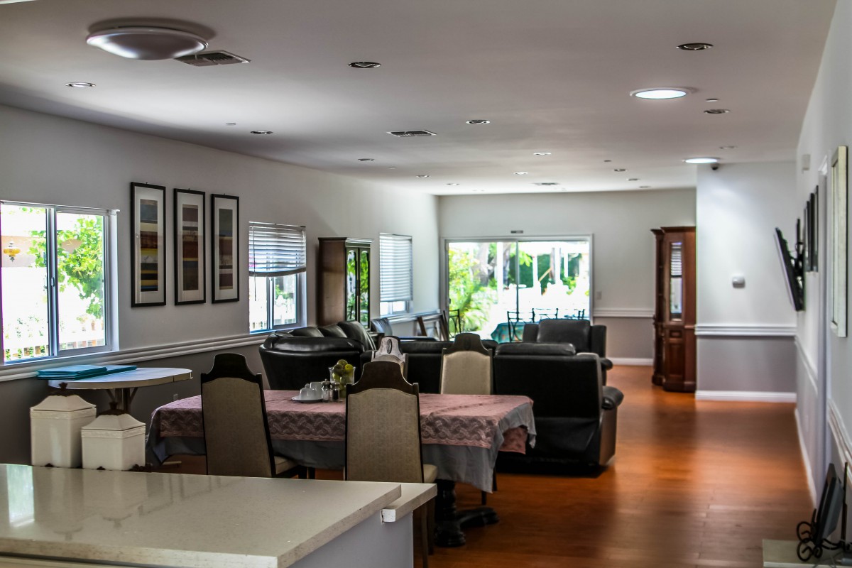 A spacious and well-lit living room with a dining area, showcasing modern interior design and comfortable furniture.