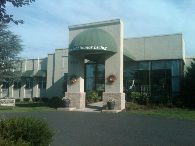 The entrance to an assisted living facility with a green awning.