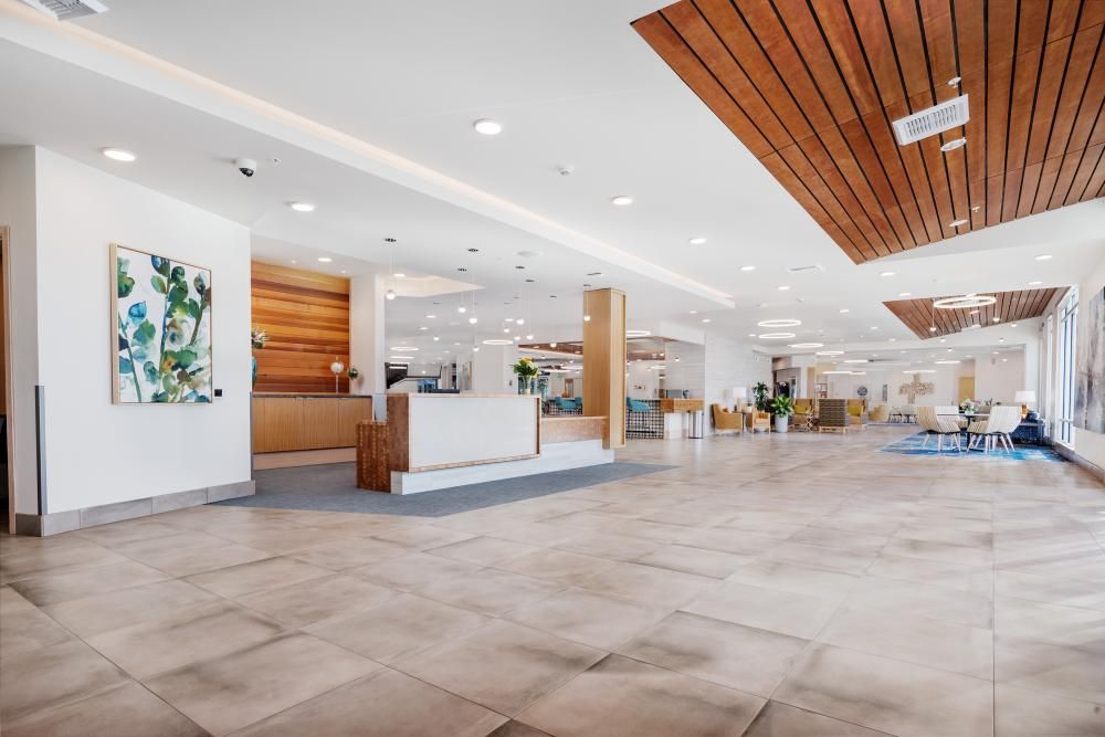 A spacious and modern lobby with wood accents and bright lighting.