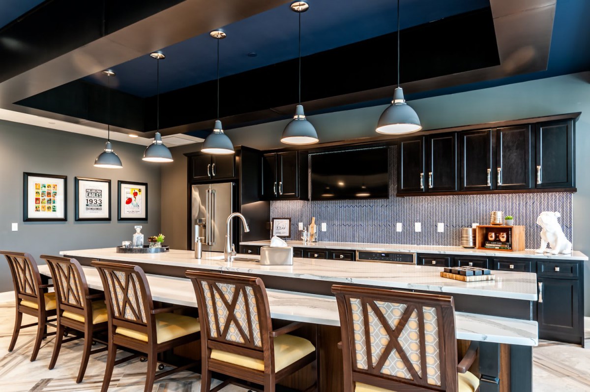 A modern kitchen with pendant lighting and a spacious island.