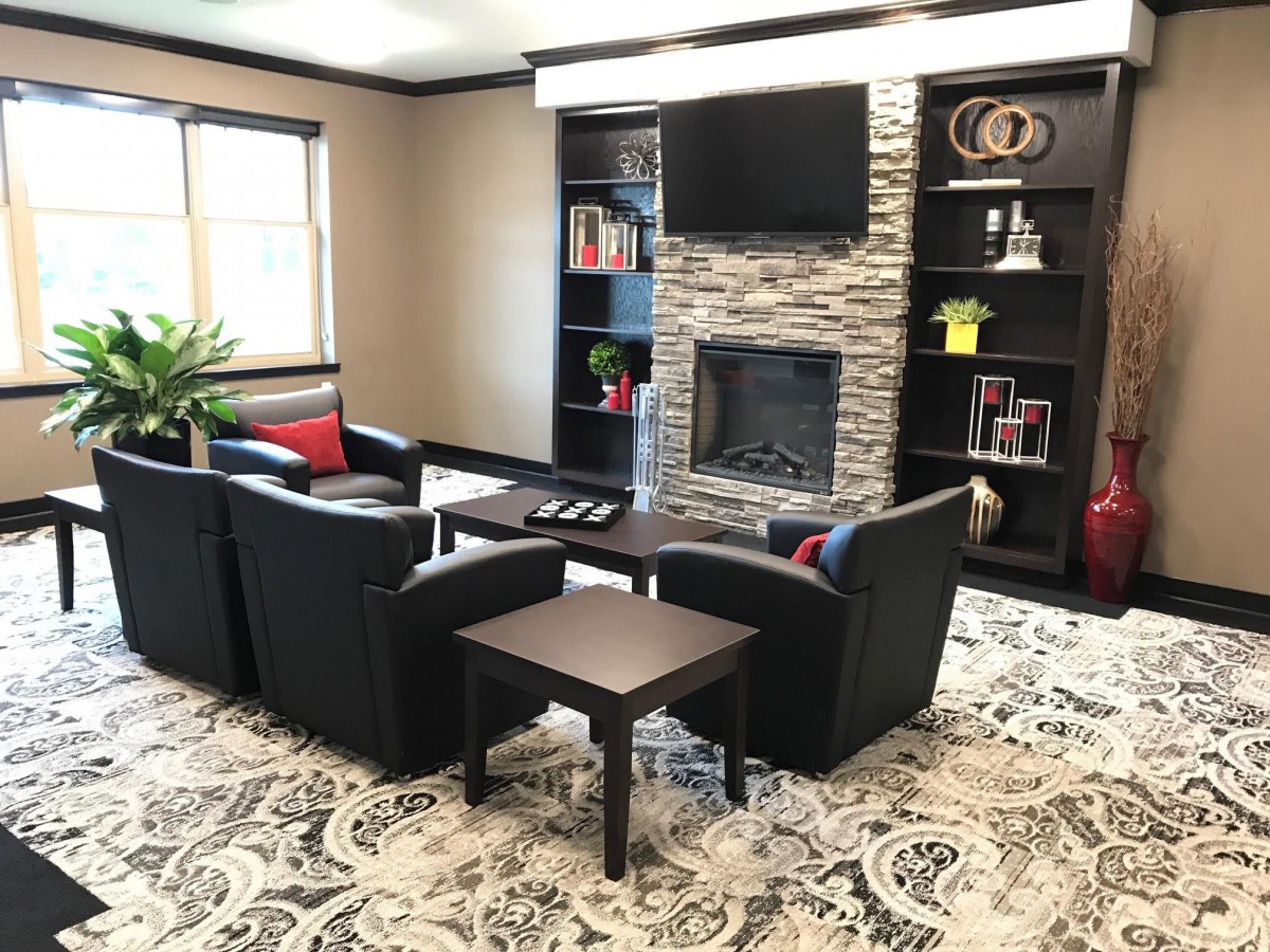 A modern living room with a stone fireplace, television, and comfortable seating arrangement.