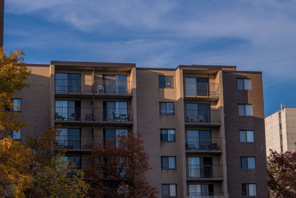 An apartment building with balconies under a clear blue sky during sunset.