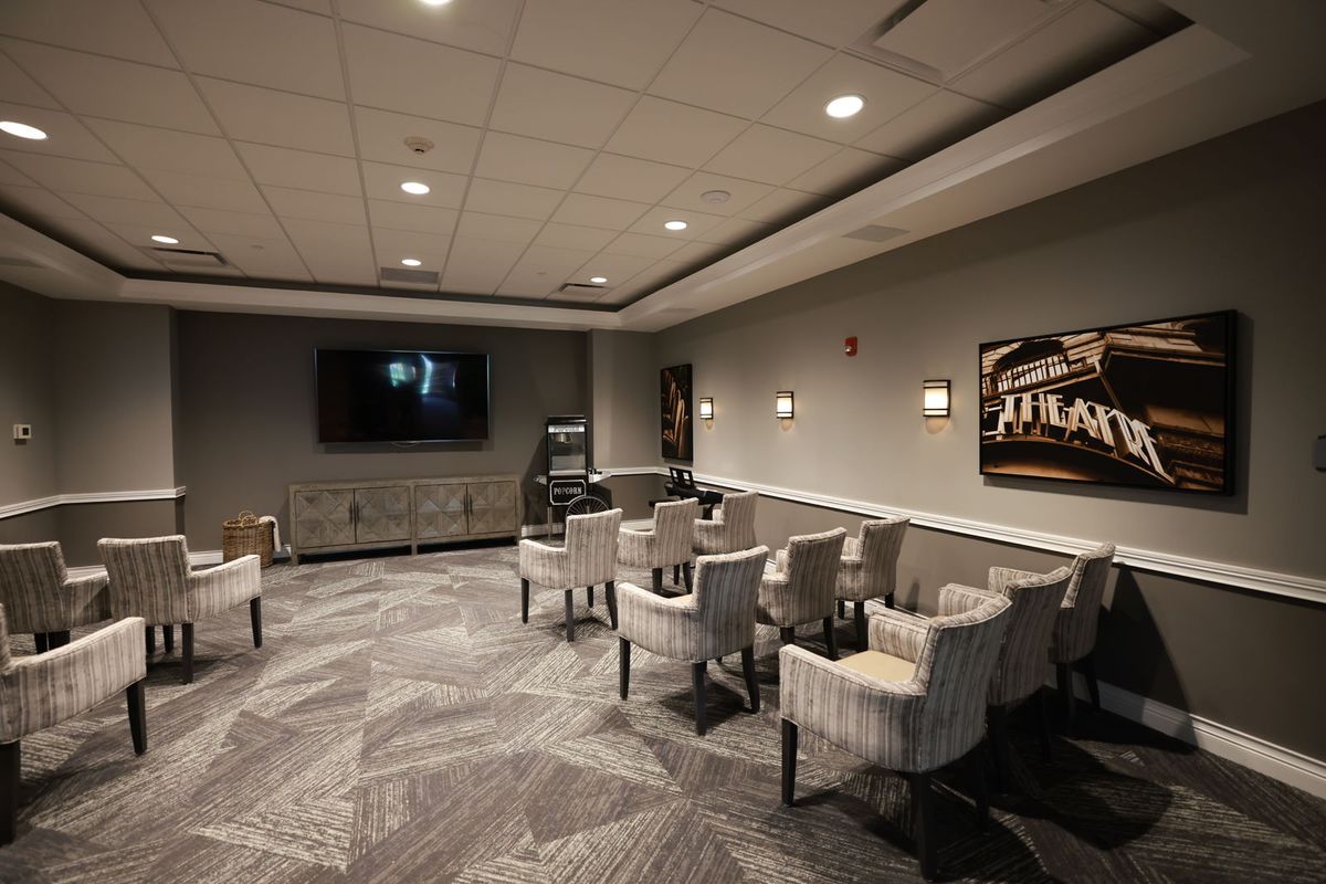A modern meeting room with a television and several chairs arranged for a conference.