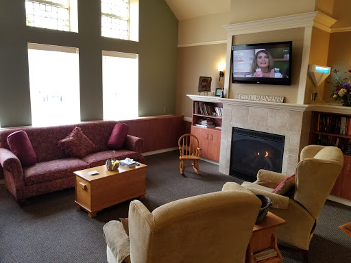 A cozy living room featuring a comfortable sofa, a television mounted on the wall, and a warm fireplace.