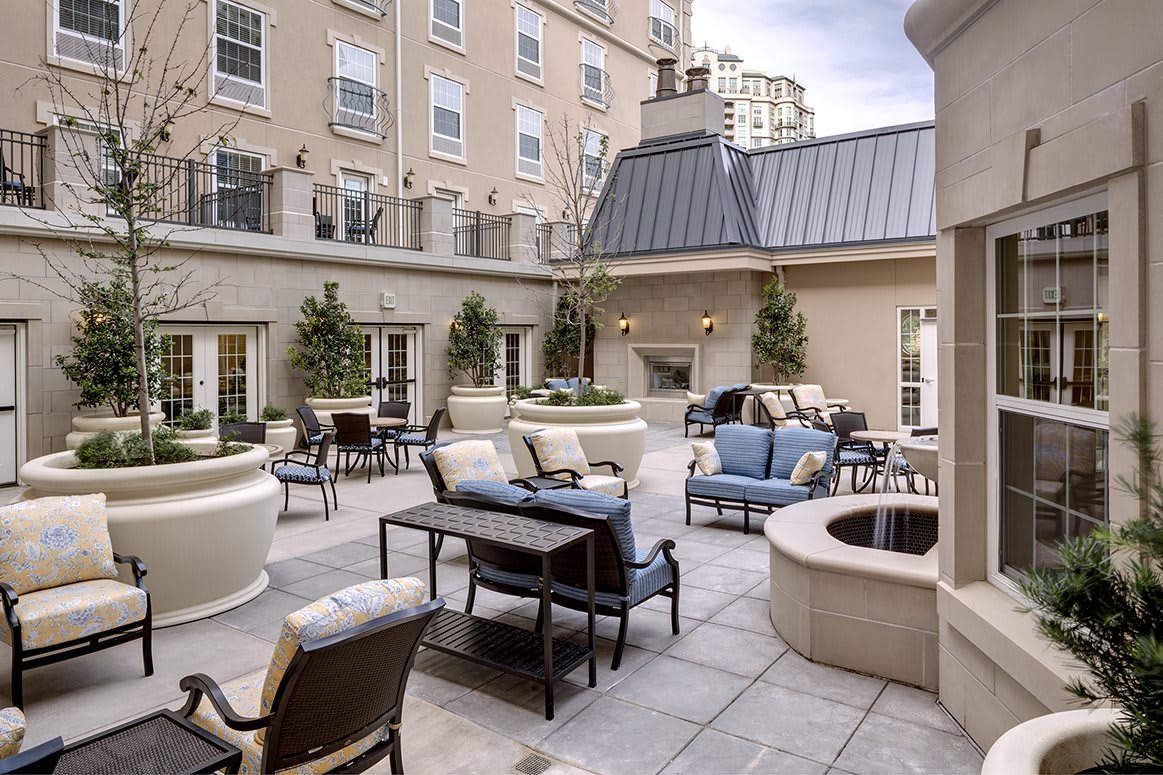 A stylish outdoor patio with comfortable seating and greenery in an urban setting.