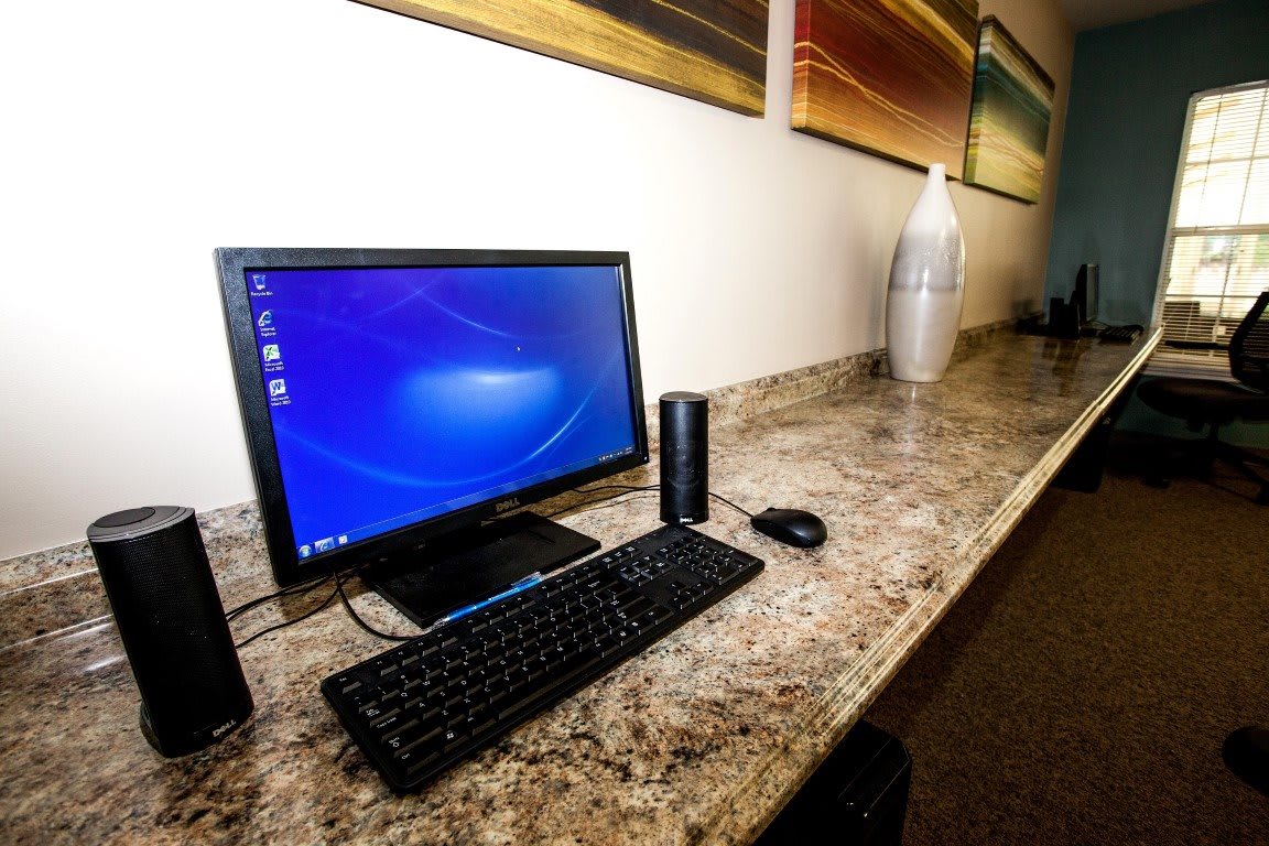 A neatly organized office workstation with a computer, keyboard, and mouse on a marble desk.
