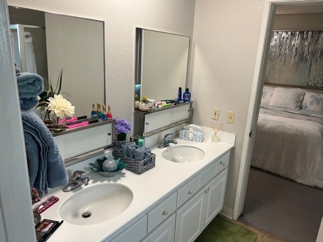 Modern bathroom with double sinks and neatly arranged toiletries.