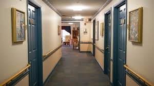 A hallway with multiple doors and a seating area at the end.