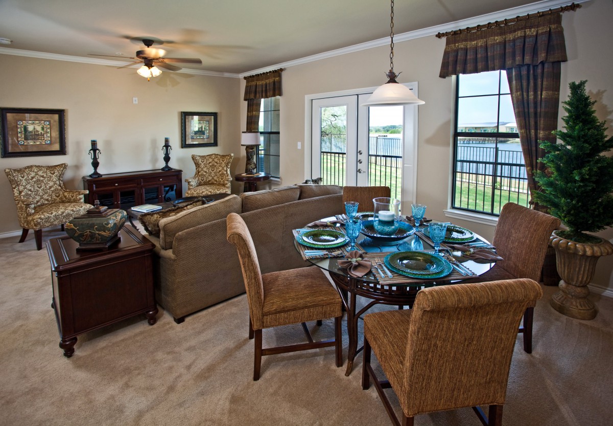A cozy living and dining area with elegant furnishings and a scenic view through large windows.