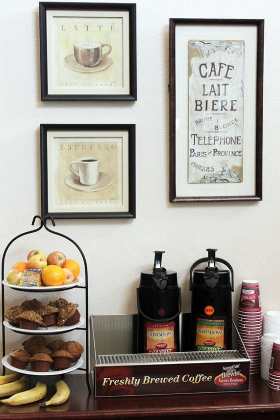 A cozy coffee station with pastries and framed wall art.